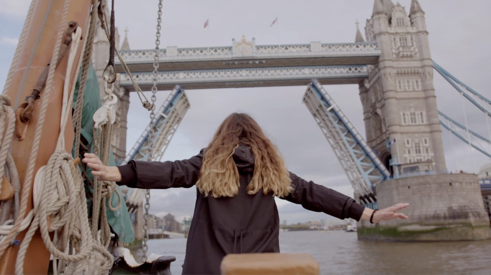 The Beginning at the End: the artist opens her arms toward Tower Bridge as it lifts